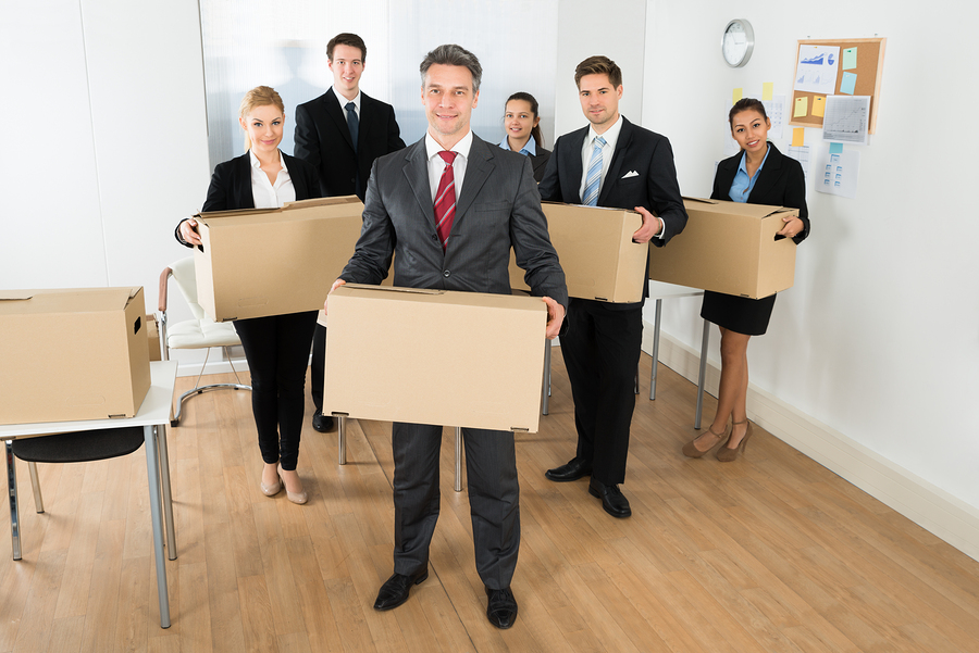 Employees In Office Holding Cardboard Boxes
